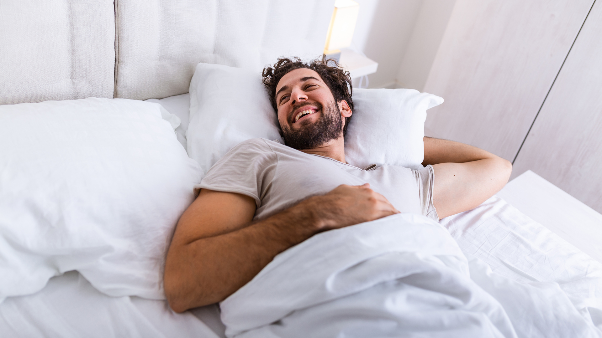 Un homme se réveille reposé après avoir mieux dormi.