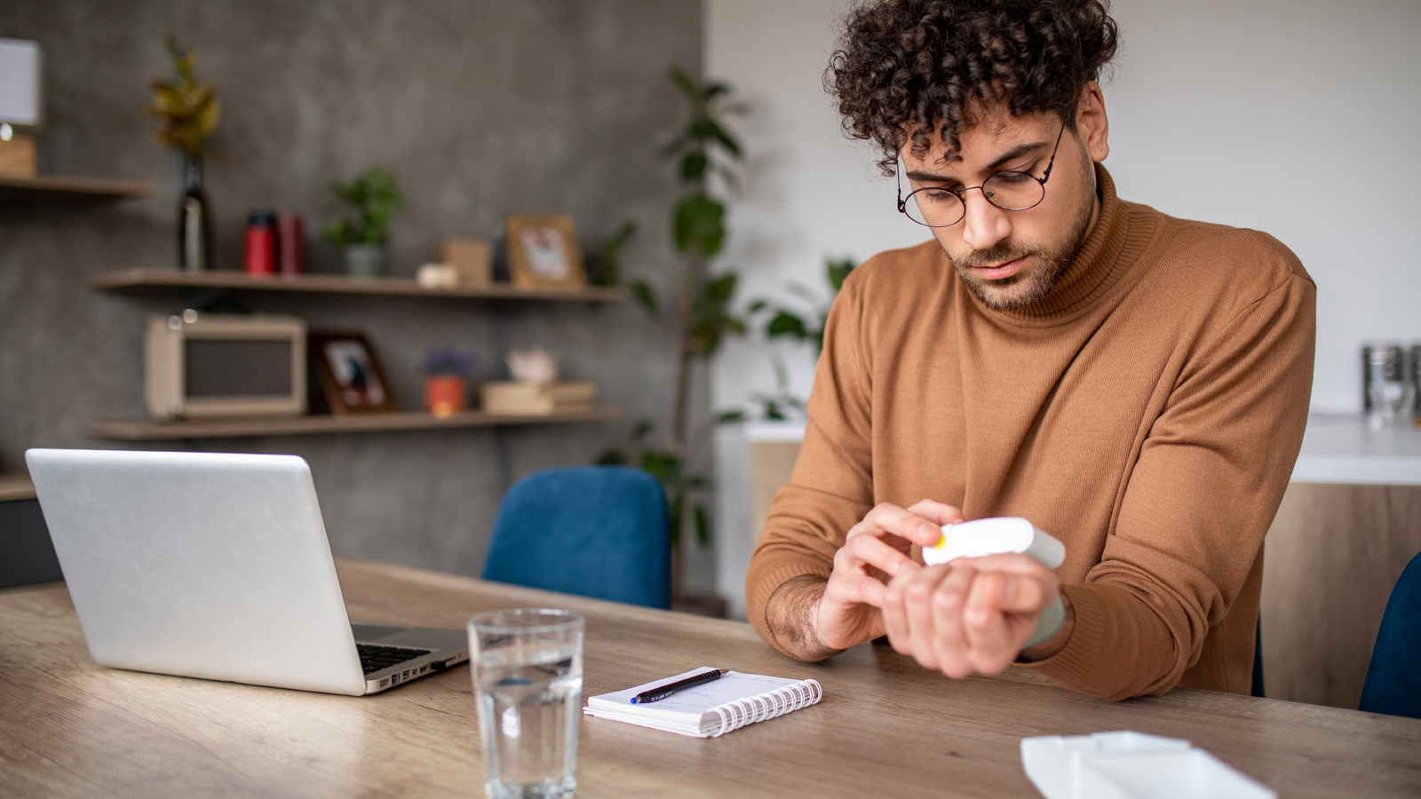 Homme mesurant sa tension artérielle à domicile avec un appareil digital pour pouvoir baisser la tension artérielle.